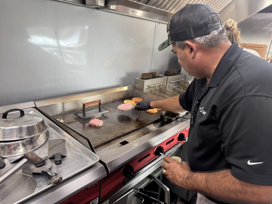 a man in a kitchen cooking food on a stove