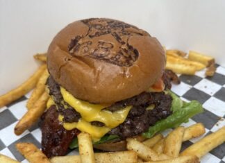 a cheeseburger with fries on a checkered table cloth