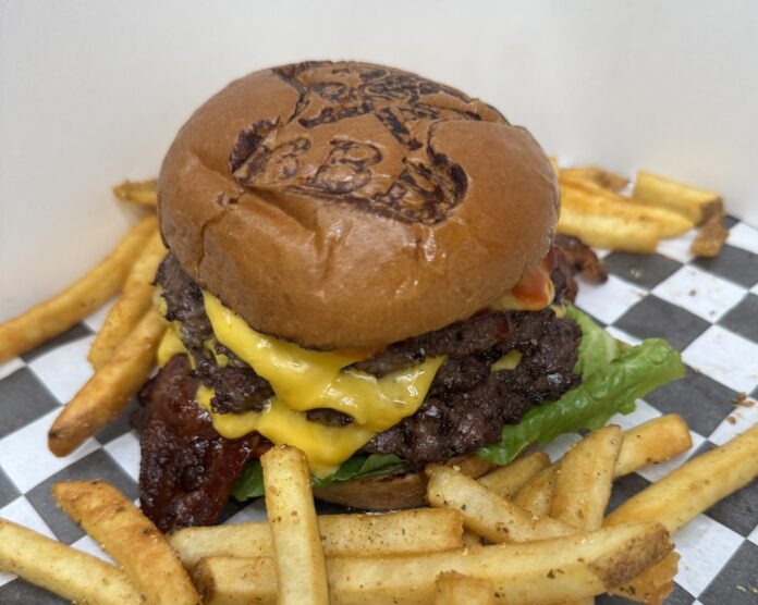 a cheeseburger with fries on a checkered table cloth