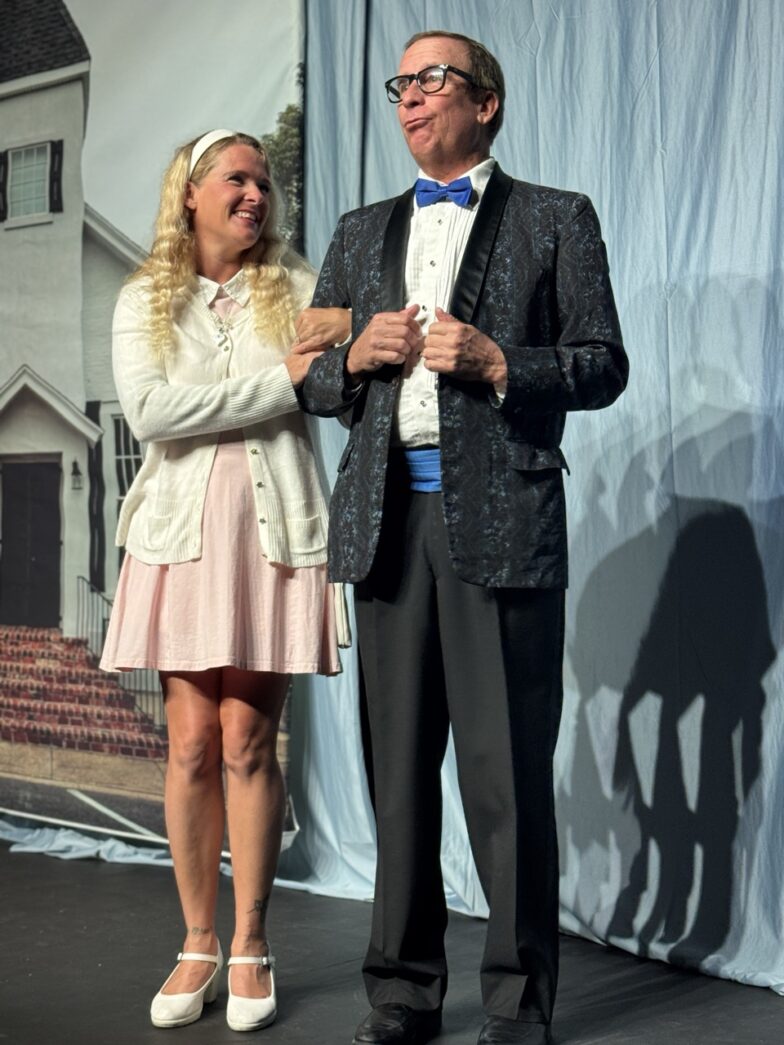 a man standing next to a woman on a stage