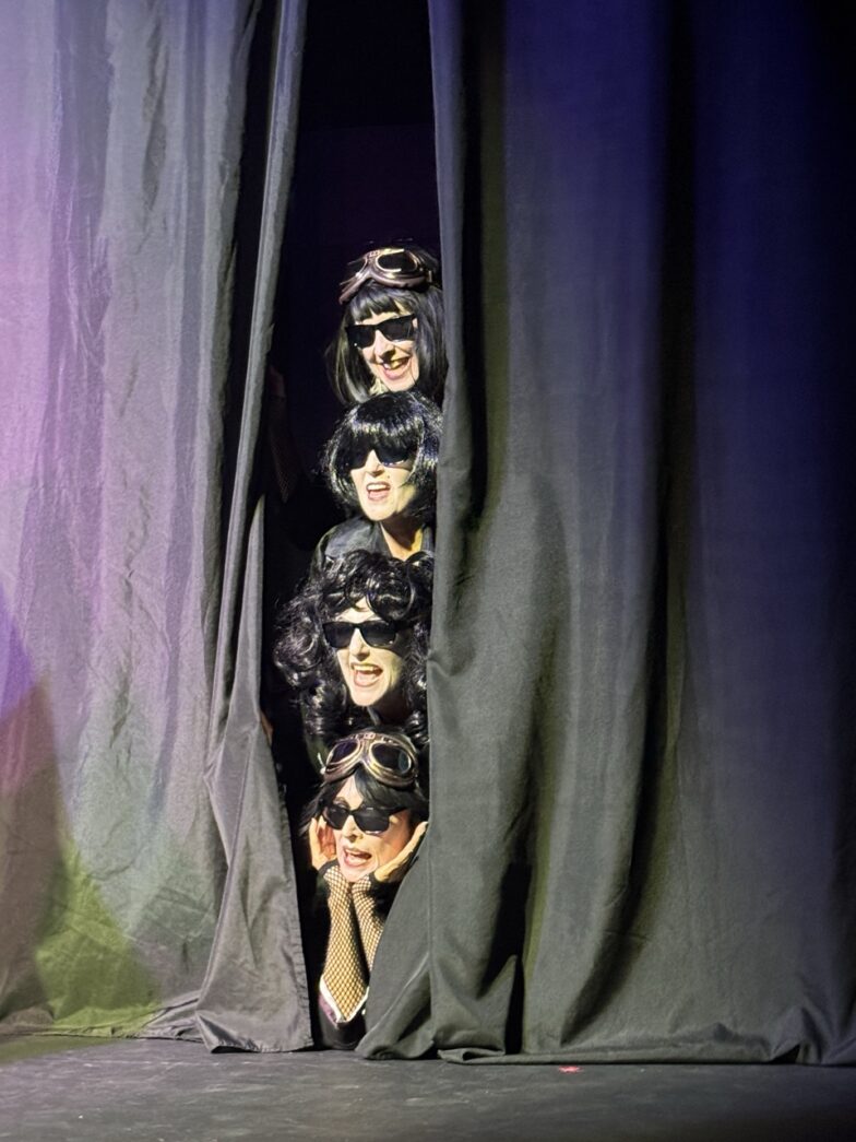 a group of people standing behind a curtain