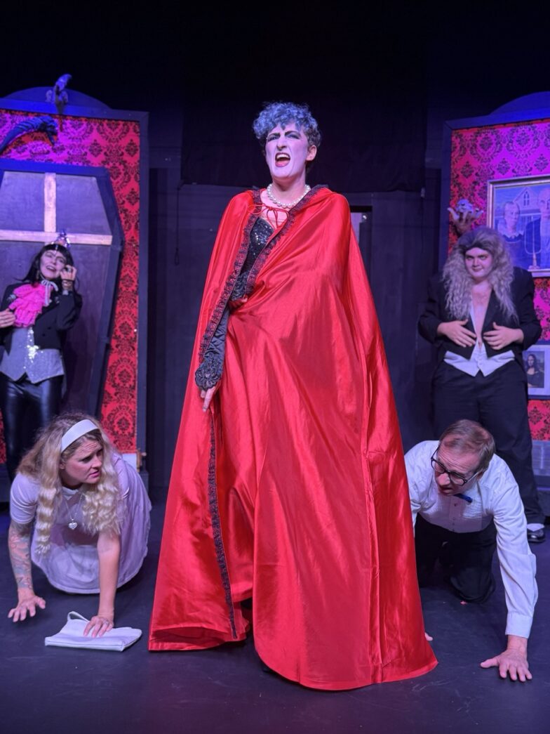 a woman in a red cape standing on a stage