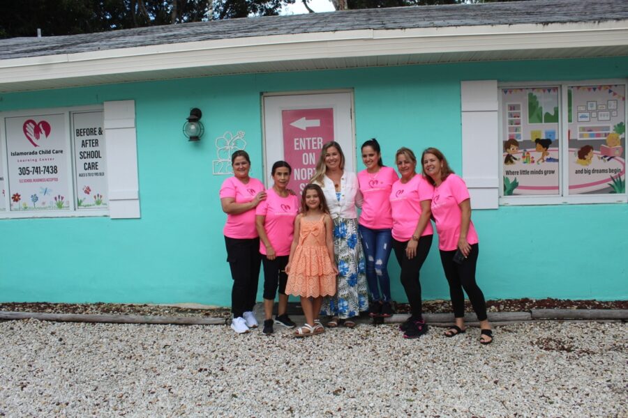 a group of women in pink shirts standing in front of a building