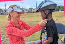 a woman helping a young boy with a helmet