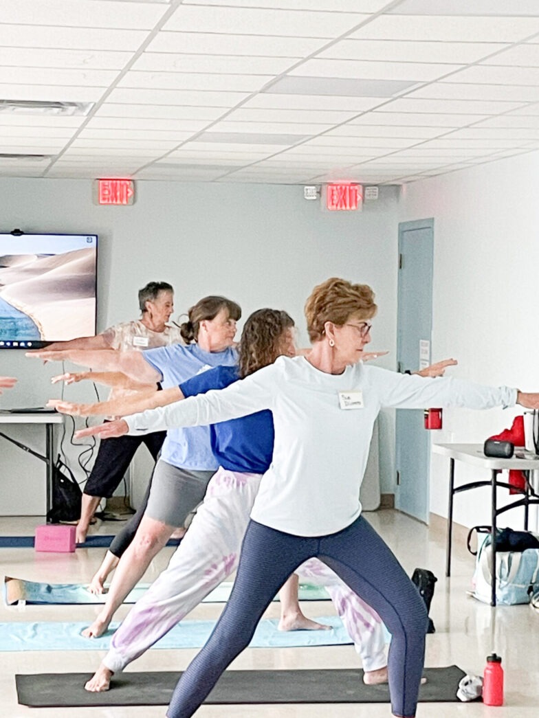a group of people doing yoga in a room