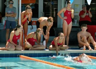 a group of people sitting around a swimming pool
