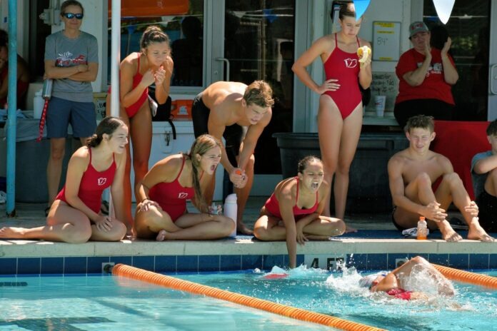 a group of people sitting around a swimming pool