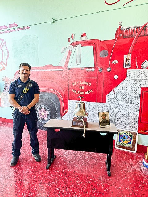 a man standing in front of a fire truck mural