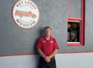a man leaning against a wall in front of a business