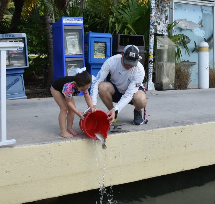a man and a little girl playing with a red bucket