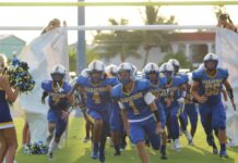 a football team running onto the field