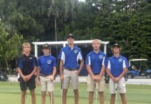 a group of young men standing next to each other on a green