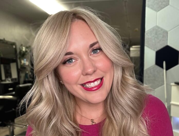 a woman with blonde hair and a pink shirt