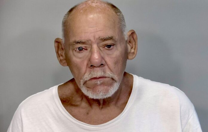 a man in a white shirt looking at the camera