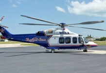 a blue and white helicopter sitting on top of an airport tarmac