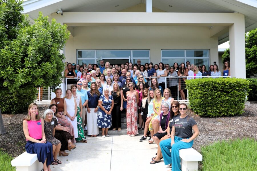 a group of people standing and sitting in front of a house