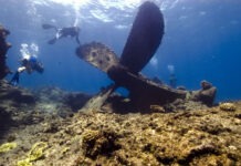 a group of people swimming over a coral reef