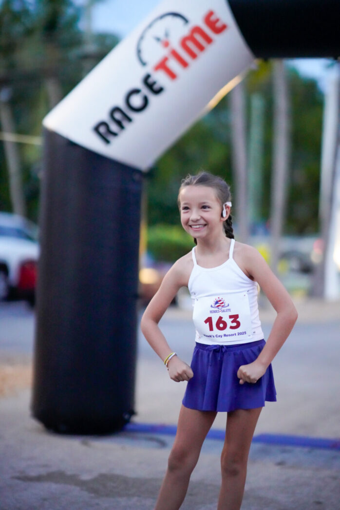 a young girl standing in front of a sign