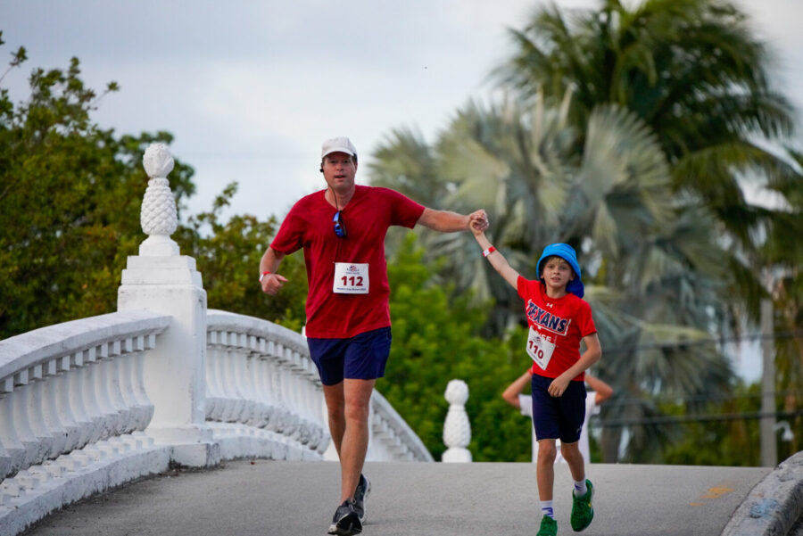 a man and a boy running across a bridge