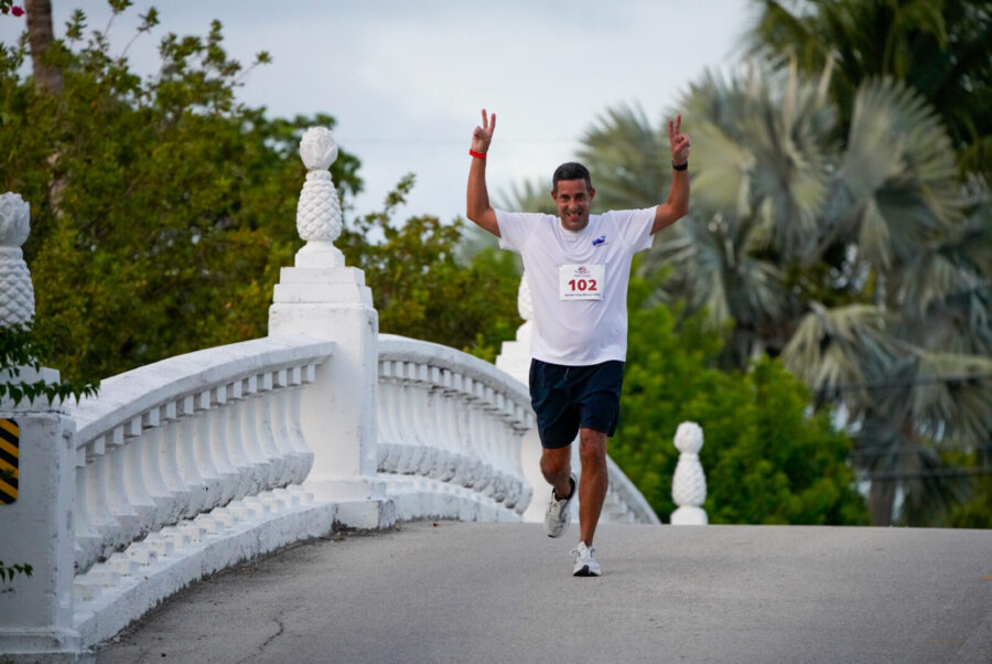 a man running across a bridge with his arms in the air