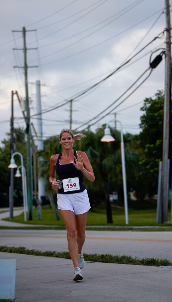 a woman running down a street next to power lines