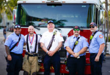 a group of men standing in front of a fire truck