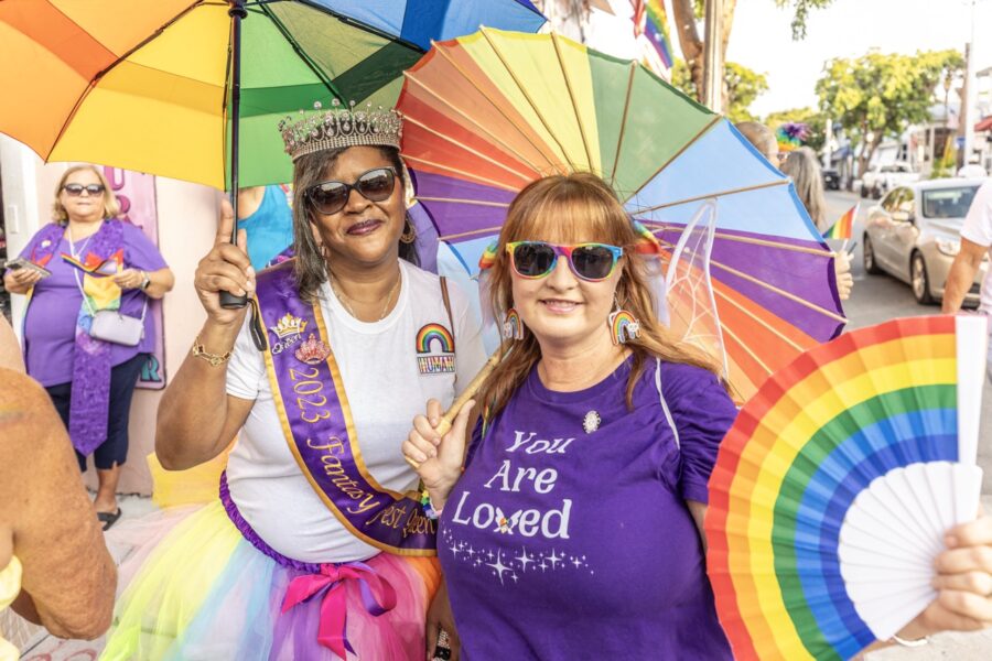 a couple of women standing next to each other holding umbrellas