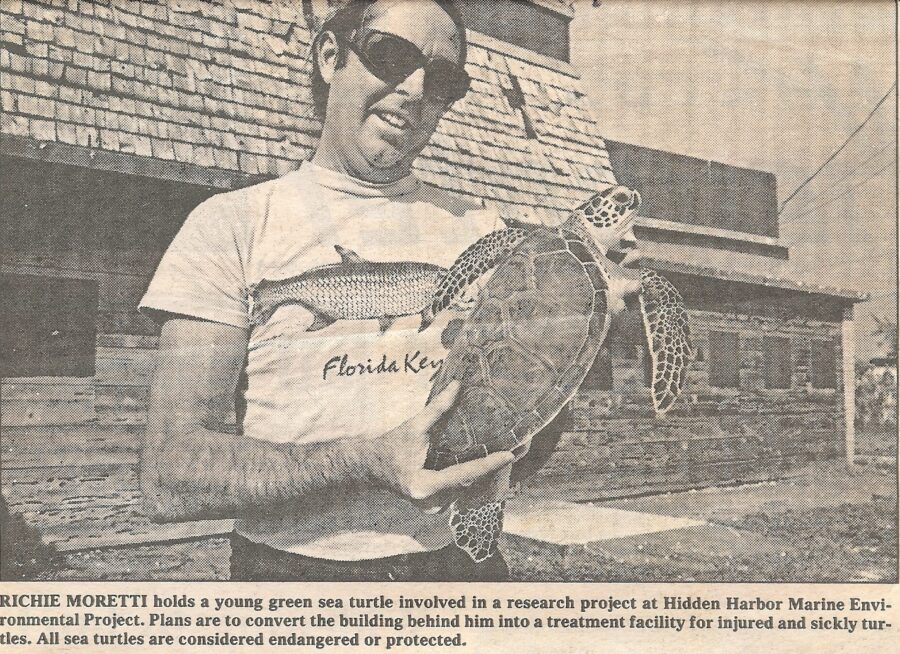 a man holding a turtle in front of a building