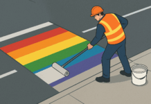 a man with a paint roller painting a rainbow rug