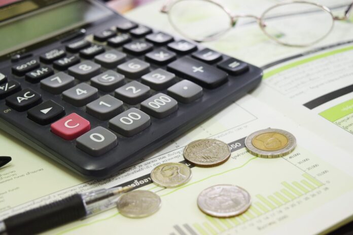 a calculator sitting on top of a desk next to a pen