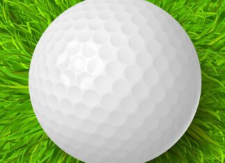 a white golf ball sitting on top of a lush green field