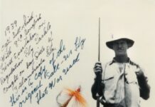 a man holding a fish on a fishing rod