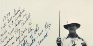 a man holding a fish on a fishing rod