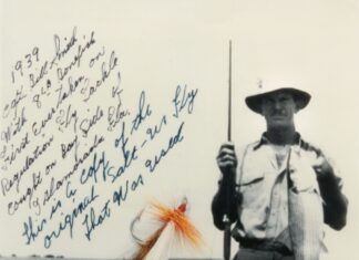 a man holding a fish on a fishing rod