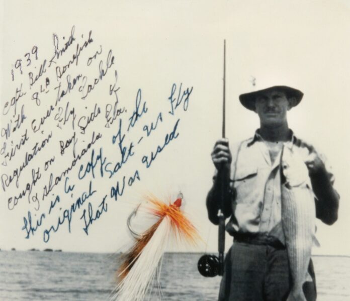 a man holding a fish on a fishing rod