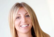 a woman with long blonde hair smiling at the camera