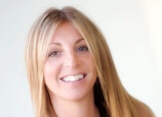 a woman with long blonde hair smiling at the camera