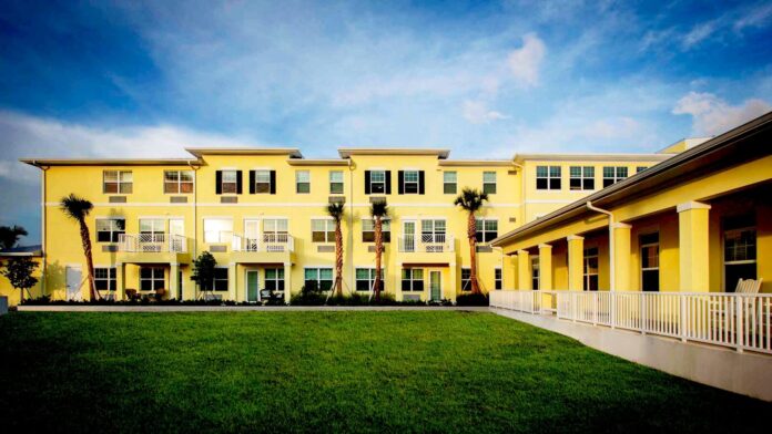 a yellow building with palm trees in front of it