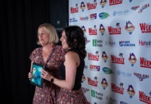 two women standing next to each other on a red carpet