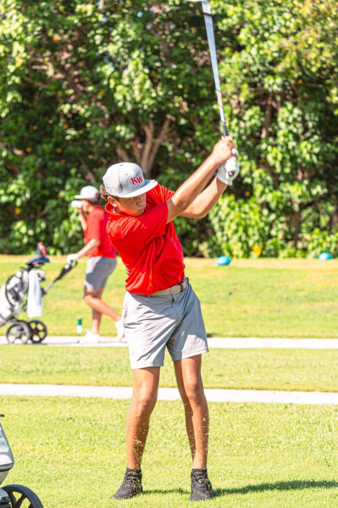 a man swinging a golf club at a ball