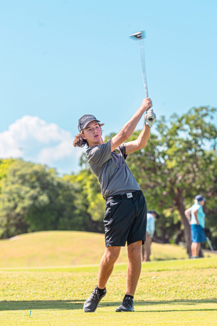 a man swinging a golf club on a golf course