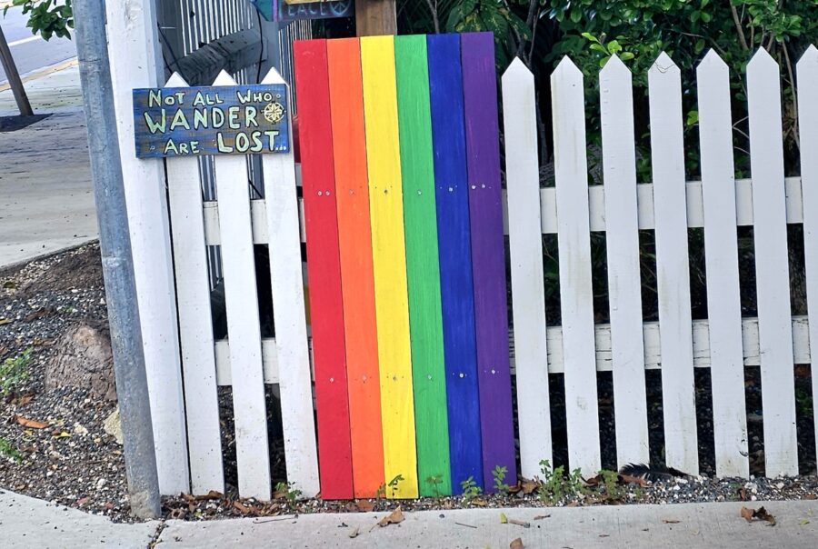 a white picket fence with a rainbow painted on it