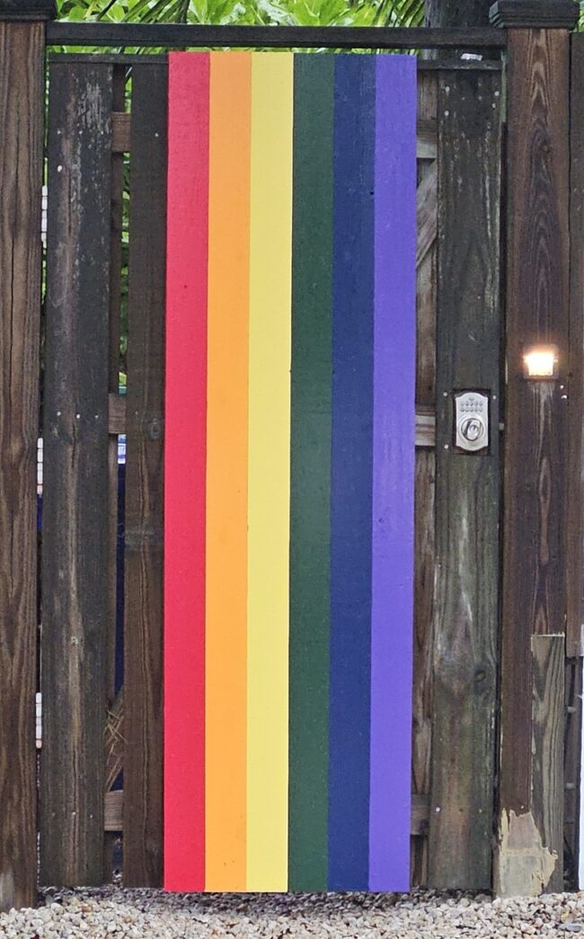 a wooden fence with a rainbow painted on it