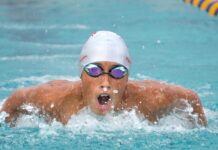 a man swimming in a pool with goggles on