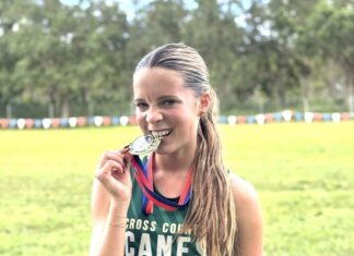 a woman holding a medal and a medal in her hand