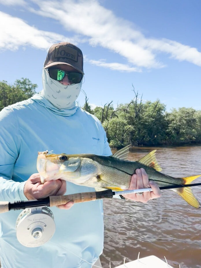 a man on a boat holding a fish