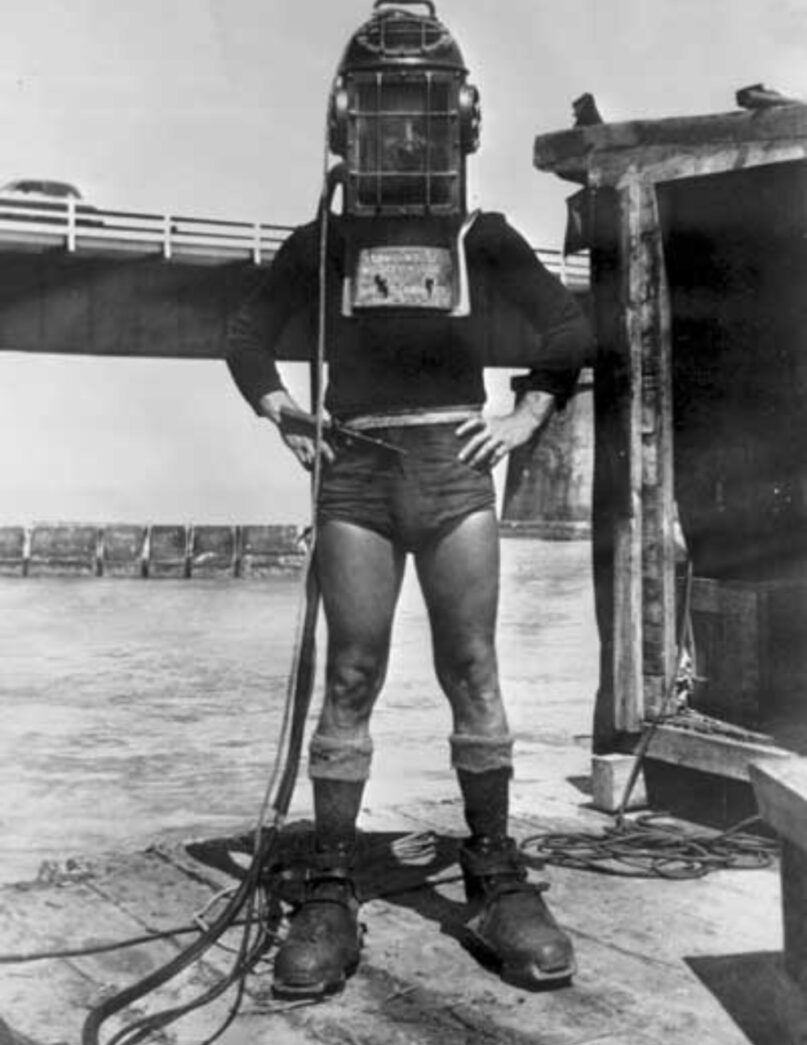 a man standing on top of a boat holding a hose