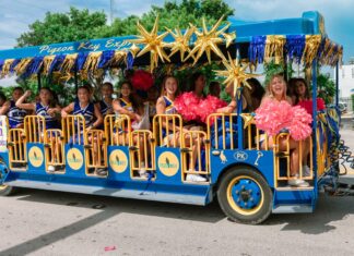 ROCKING THROUGH THE DECADES: SCENES FROM HOMECOMING 2025 IN MARATHON a group of people riding on the back of a blue bus