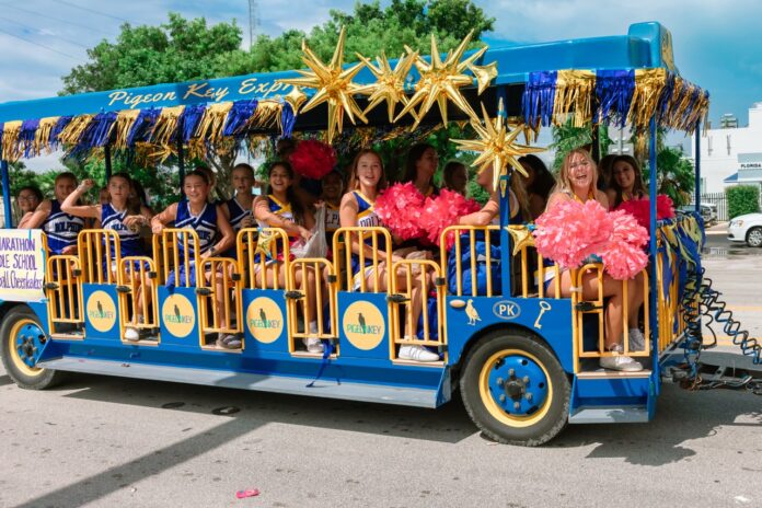 a group of people riding on the back of a blue bus