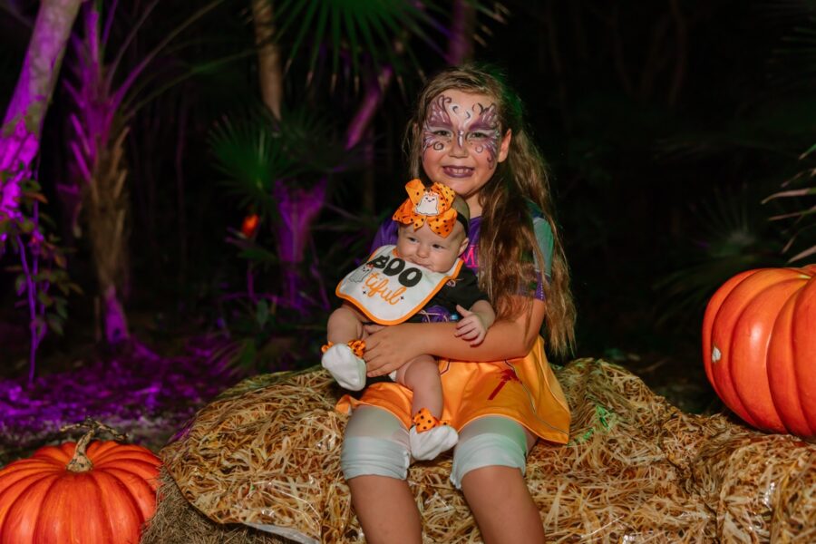 a young girl with face paint holding a baby